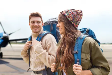 Zwei junge Menschen mit Reisegepäck fliegen in den Urlaub
