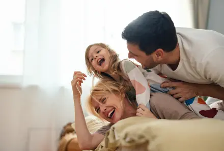 Glückliche Familie in Nachtwäsche Spaß zusammen im Schlafzimmer