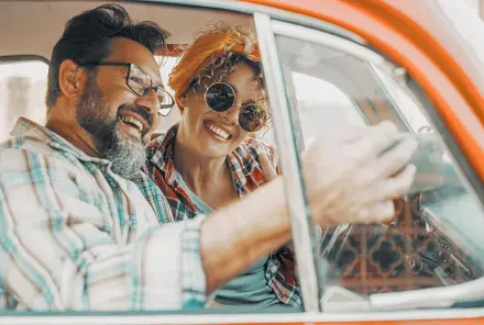 Mann und Frau sitzen im Auto und haben Spaß